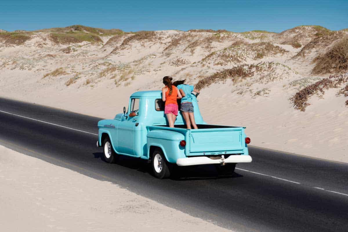 Two women carelessly riding at the back of a pickup truck,Can You Ride in the Back of a Pickup Truck? (Answers per state)
