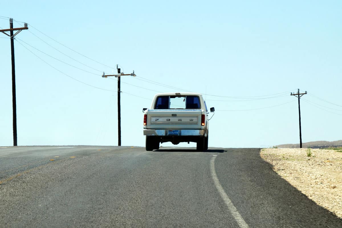pickup truck on lonesome country road in the desert of texas