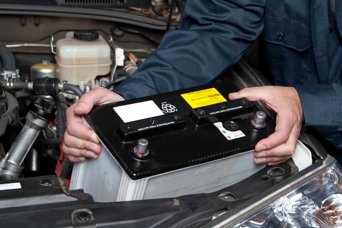 Auto mechanic replacing a car battery