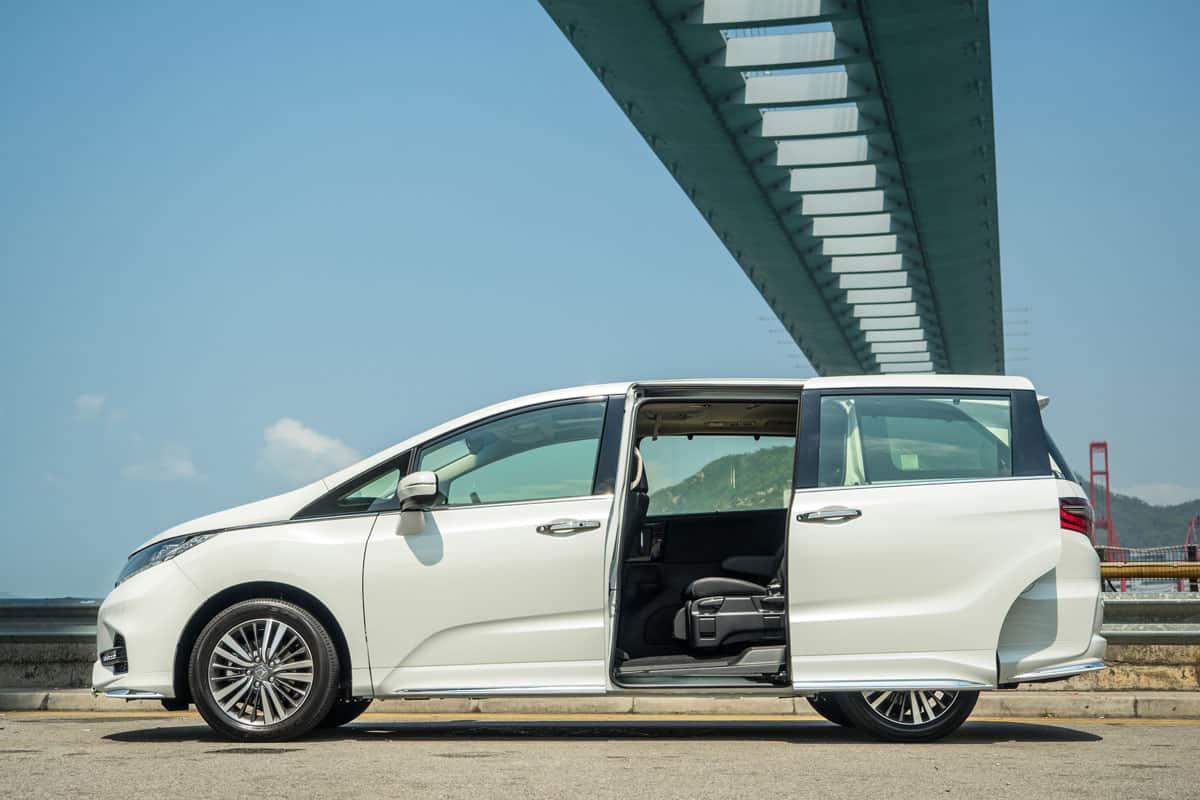 Honda Odyssey white pearl color side view open door under the bridge sunny day