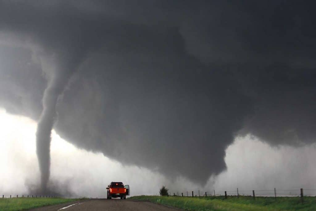 Pick up truck parked at close distance with tornado