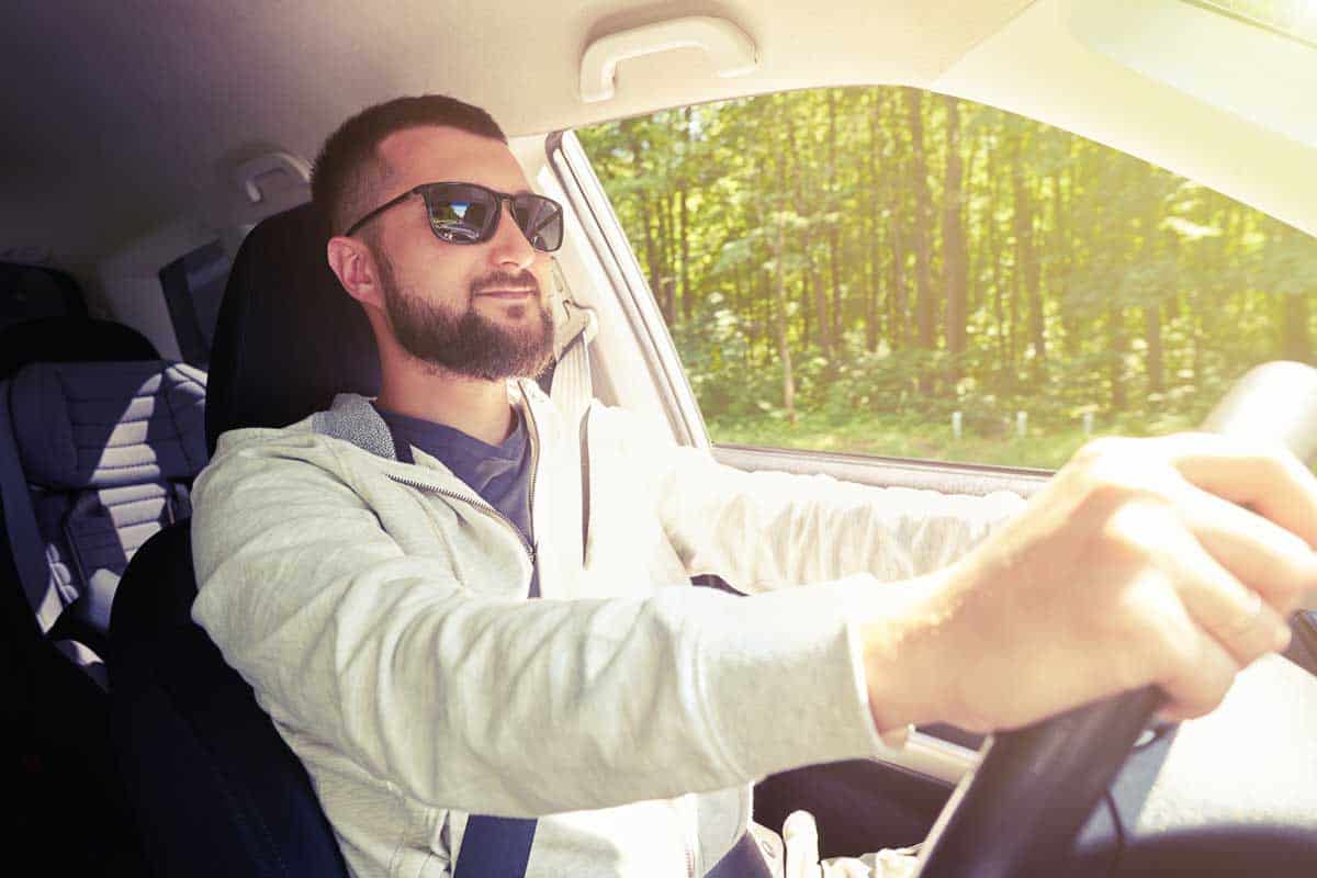 Guy wearing polarized glasses while driving, Best Polarized Glasses to Wear When Driving into the Glaring Sun