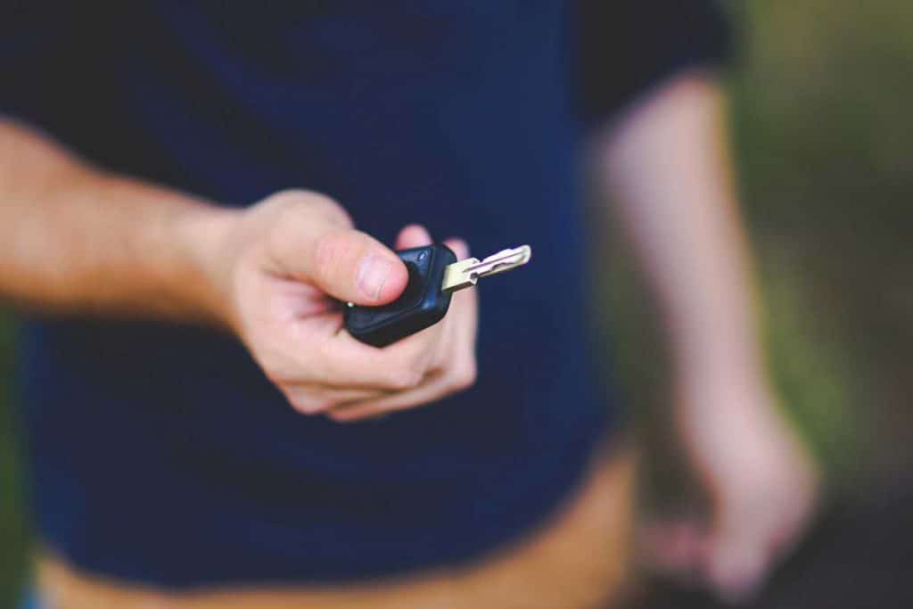 Man pressing lock/unlock button on car key