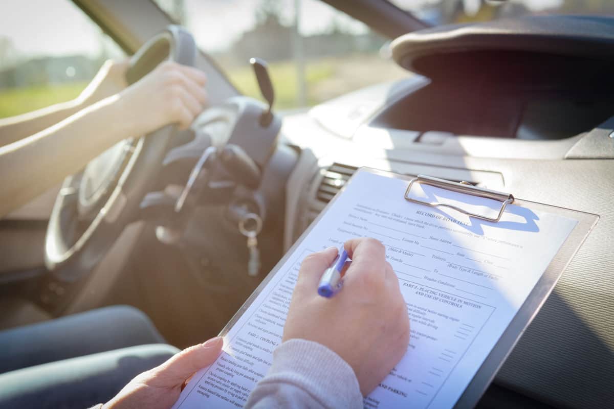 examiner filling drivers license road test
