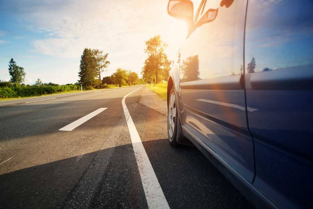 Car-on-asphalt-road-on-summer-day-at-park.-Automobile-on-highway