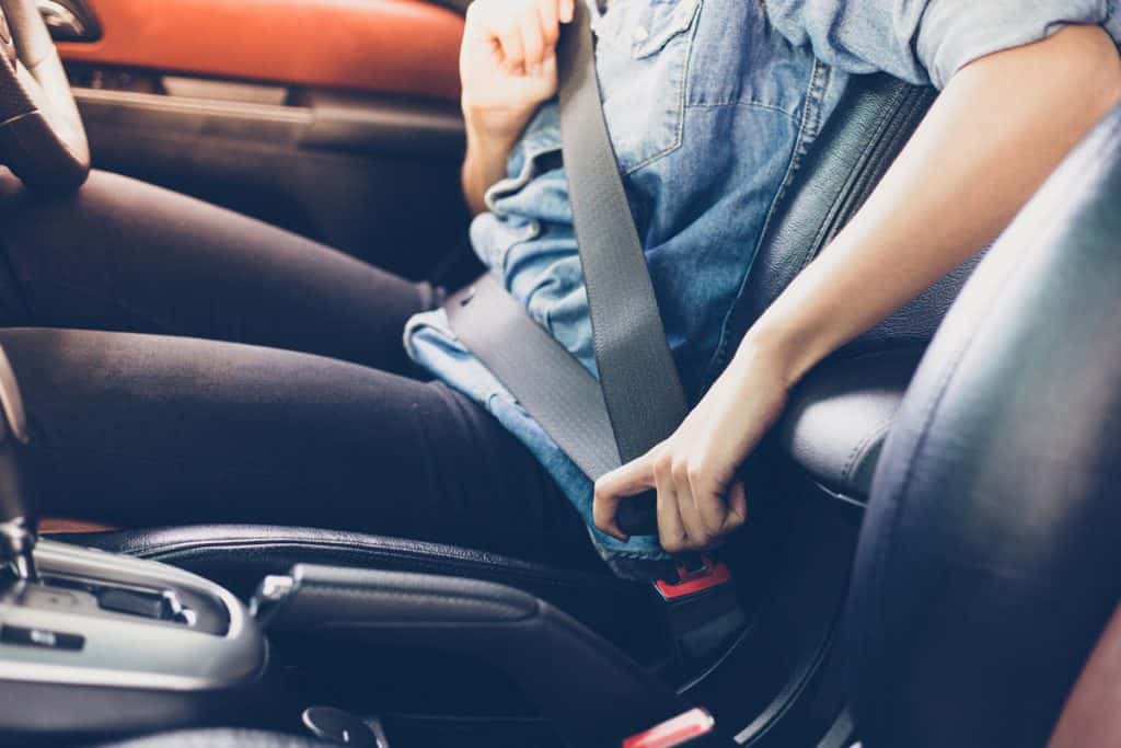 Woman putting seat belts on for safety