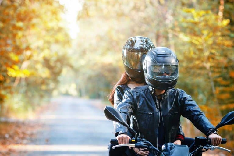 Couple wearing helmets driving down the road on motorcycle, 10 Types of Motorcycle Helmets