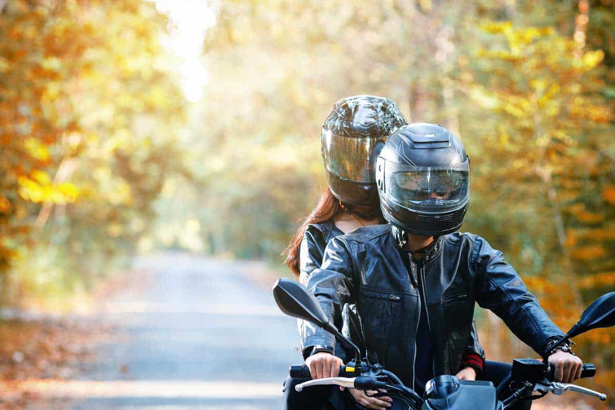 Couple wearing helmets driving down the road on motorcycle, 10 Types of Motorcycle Helmets