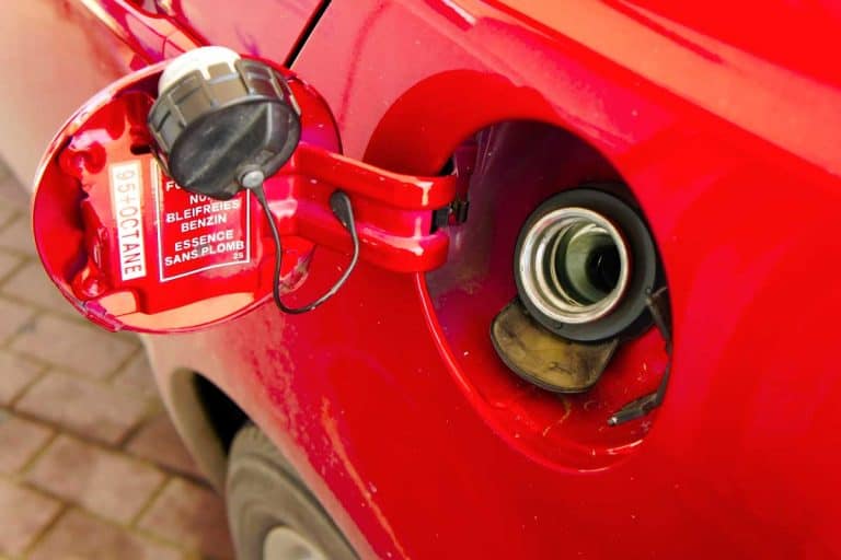 Gas tank of a red car open ready for refill, Driving Without a Gas Cap - How bad is it?