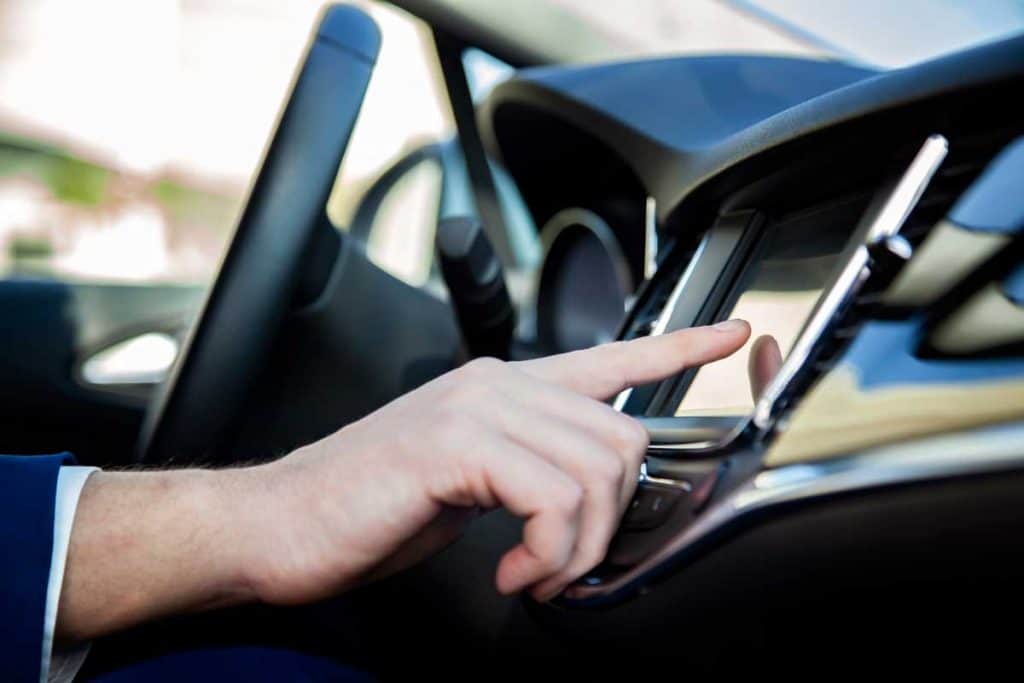 Man touching LED touchscreen monitor in car