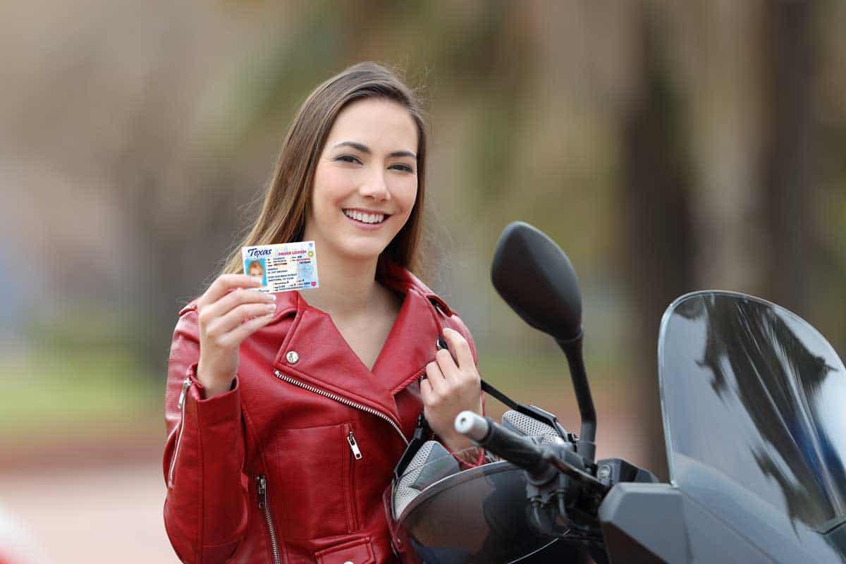 Happy biker girl showing a texas driver's license card on the street, How to Get a Motorcycle License in Texas