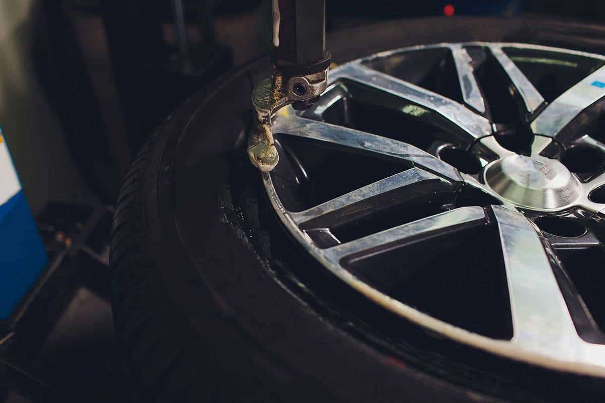 Close up view of a wheel being balanced and installed with the tubeless tire of the car on the balancer in the workshop