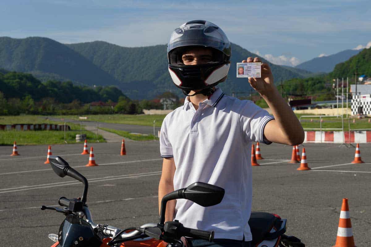 Young man in a helmet on the motorbike is showing driving license, How To Get A Motorcycle License In Pennsylvania