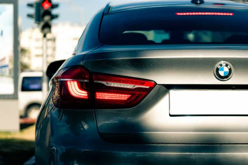 Back of grey BMW X6 car with tail brake light on, Brake Light Comes on When Driving – What Could It Be?
