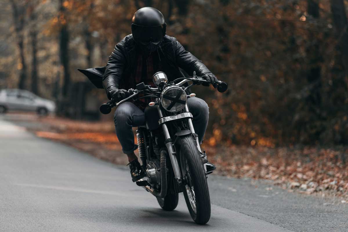 Man driving custom made motorcycle in a leather jacket during autumn, Does Riding A Motorcycle Burn Calories?