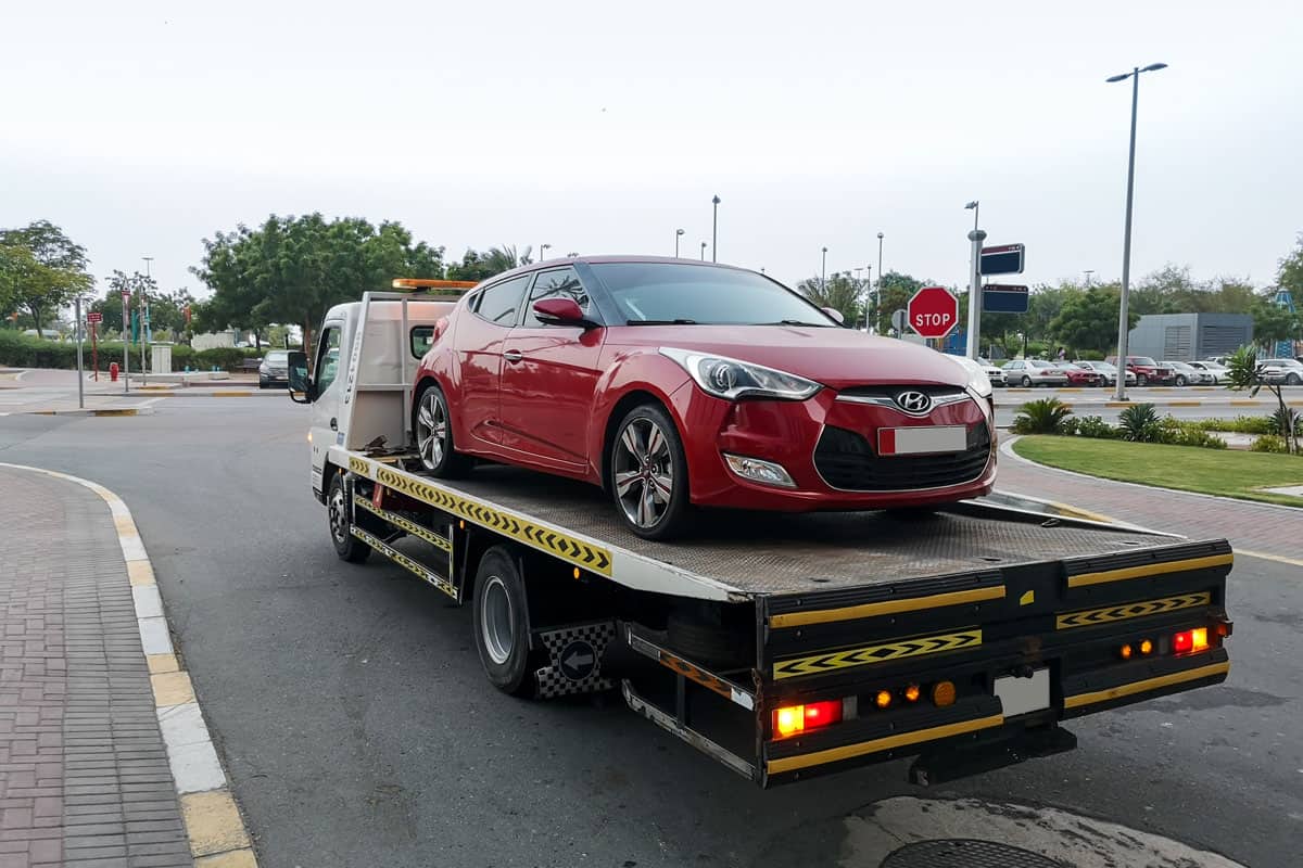 Tow truck carrying sedan due to parking violations, What Happens When Your Car Gets Towed?