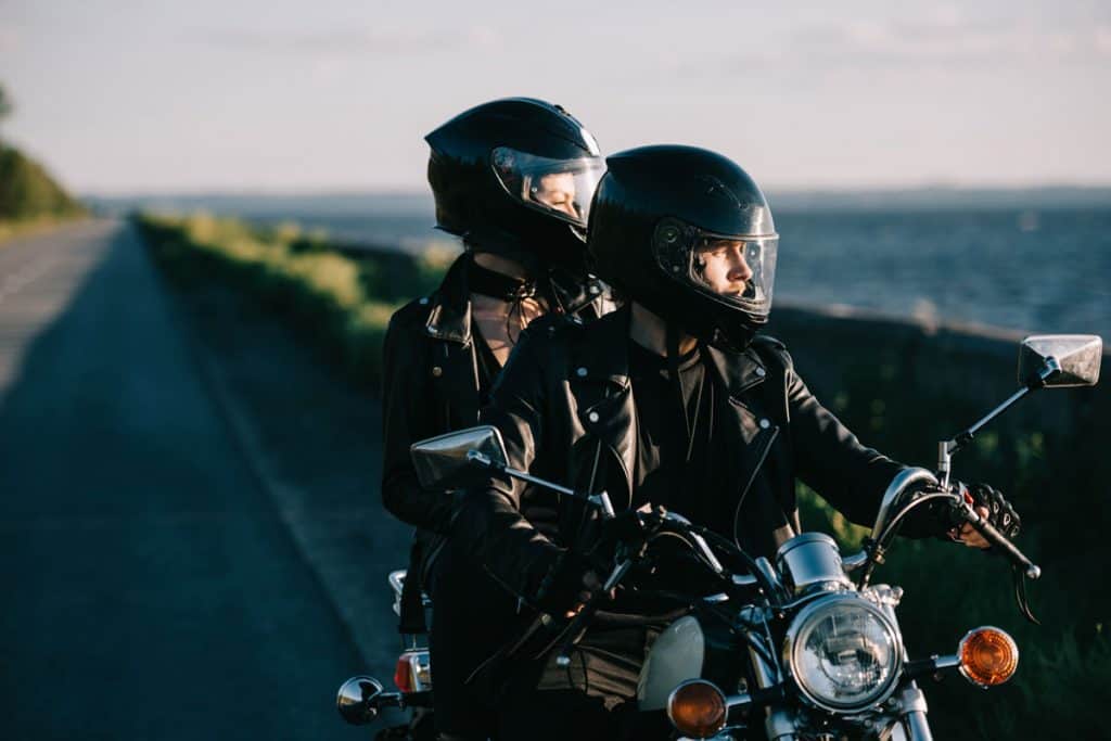 Couples wearing helmets riding on a bobber motorcycle riding on the coastline , Motorcycle Helmets With Cat Ears [Here's how to get yours]