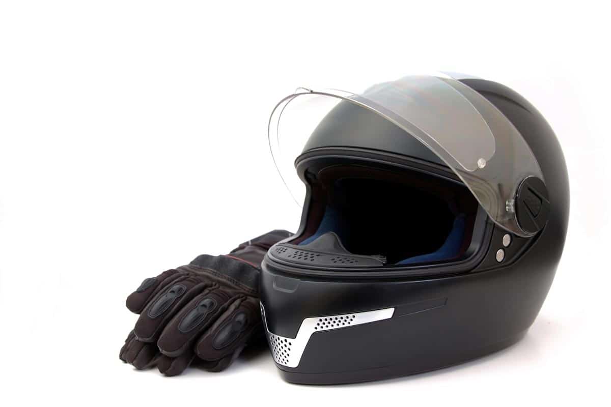 A black helmet and driving gloves against white background, Can you Reline a Motorcycle Helmet? [Step by Step Tutorial]
