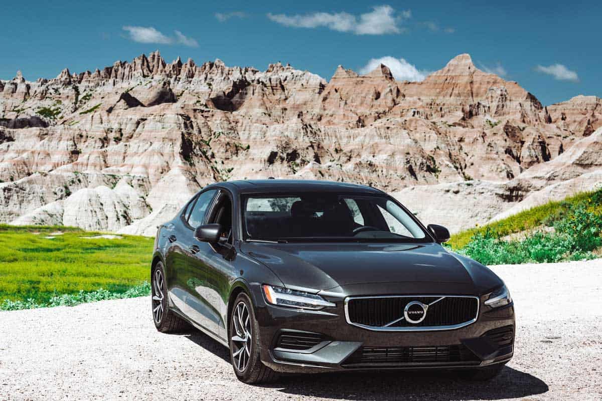 View of the new Volvo S60 T6 coupe parked on the road with the Badlands National Park in the background, What Are Foreign Cars? [Inc. Examples]