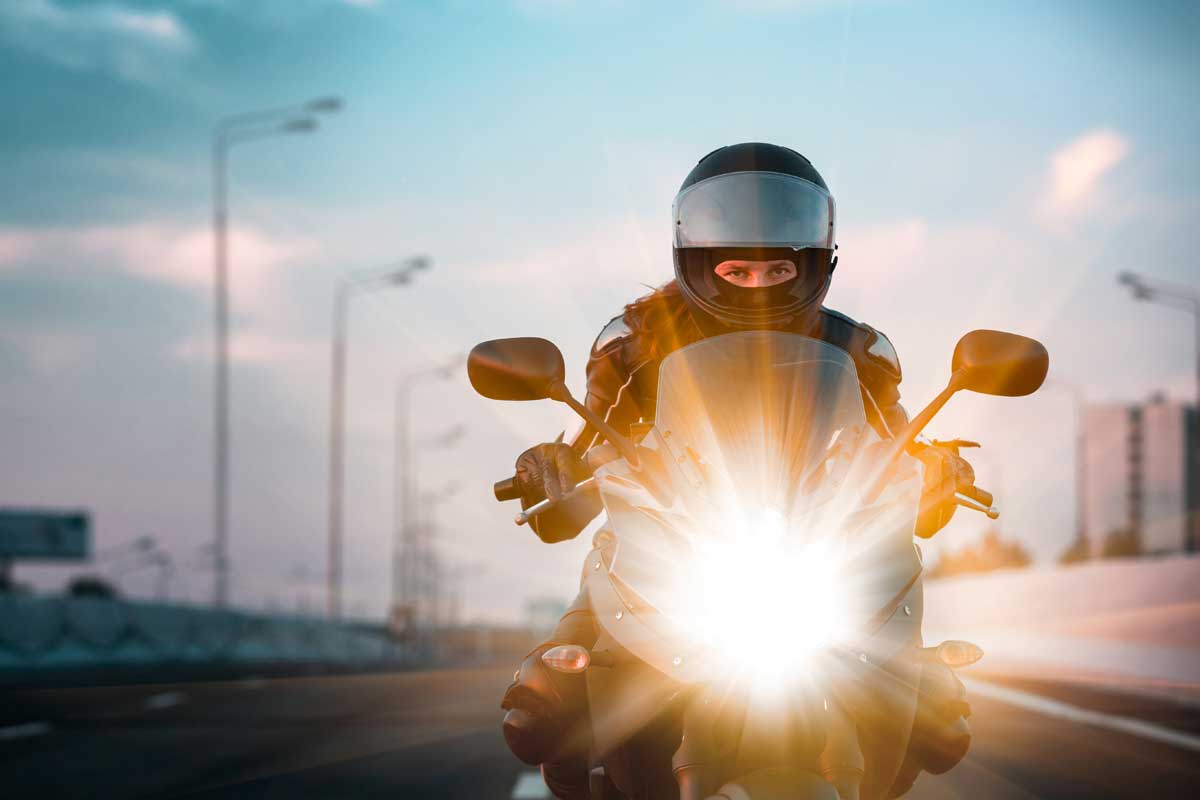 Woman drives on a motorcycle on a morning highway, Do Motorcycles Have to Pay Tolls?