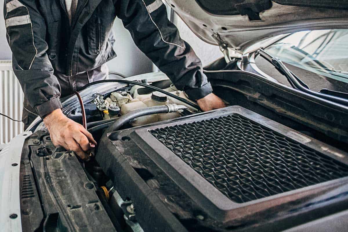 mechanic recharging car air-condition in auto repair shop