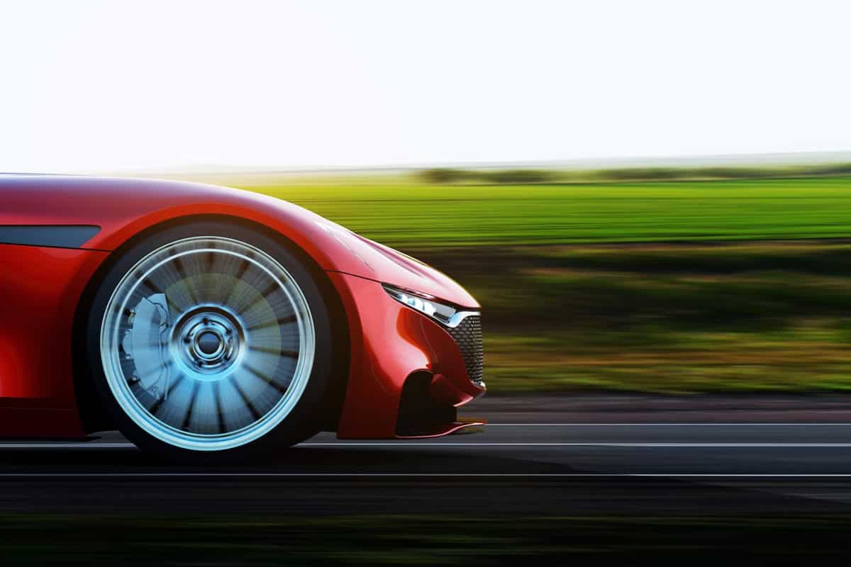 A red car moving fast on the road, What Happens if Your Car Axle Breaks While Driving?
