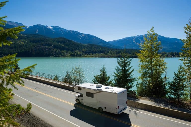 An RV moving down the road near Green Lake in Whistler, BC, Class C RVs with Bunk Beds [9 Options Reviewed]