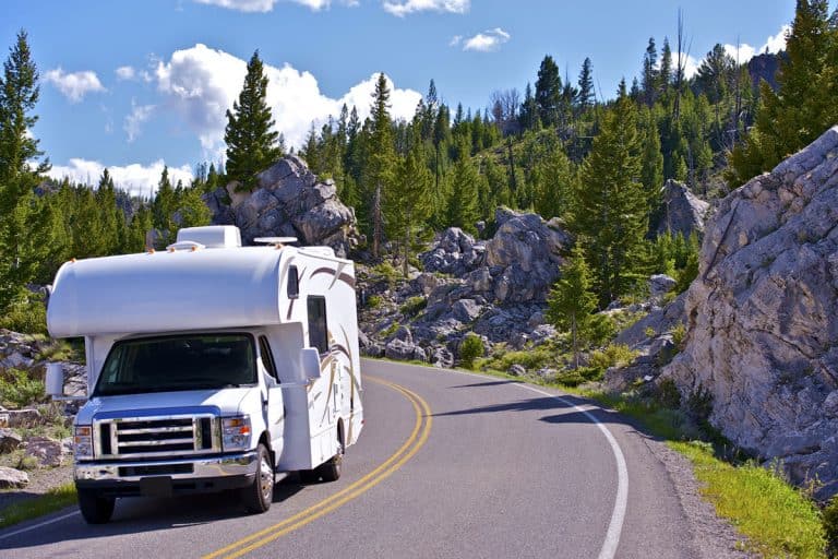 An RV moving down the road at Yellowstone national park, Top 15 RV Manufacturers And Brands