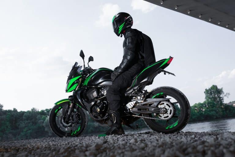 A rider sitting on his sport bike with green fairings, The Motorcycle Chain Breaker and Rivet Tools Guide