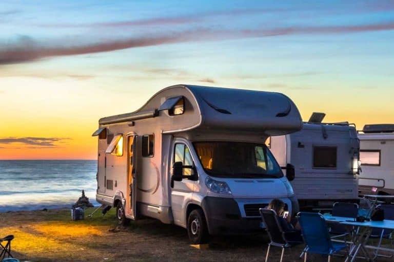 Campers and Motorhomes overlooking sunset in the Mediterranean sea from their campsite on the beach, How Many People Can Ride In An RV? [By RV Type and Size]