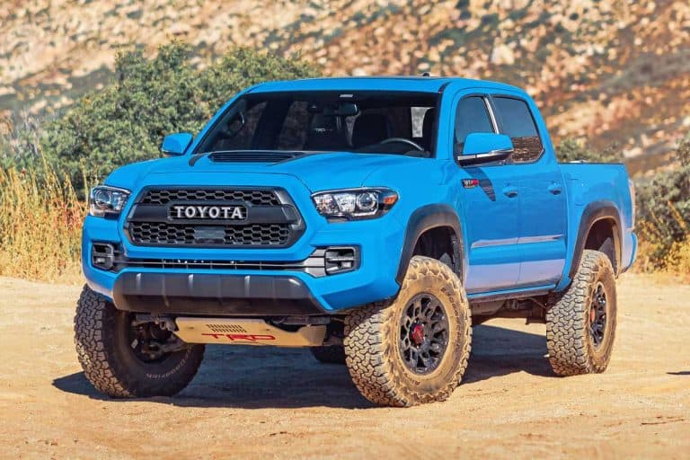A blue Toyota Tacoma off-roading in the mountains, How Much Legroom Does A Tacoma Truck Have?