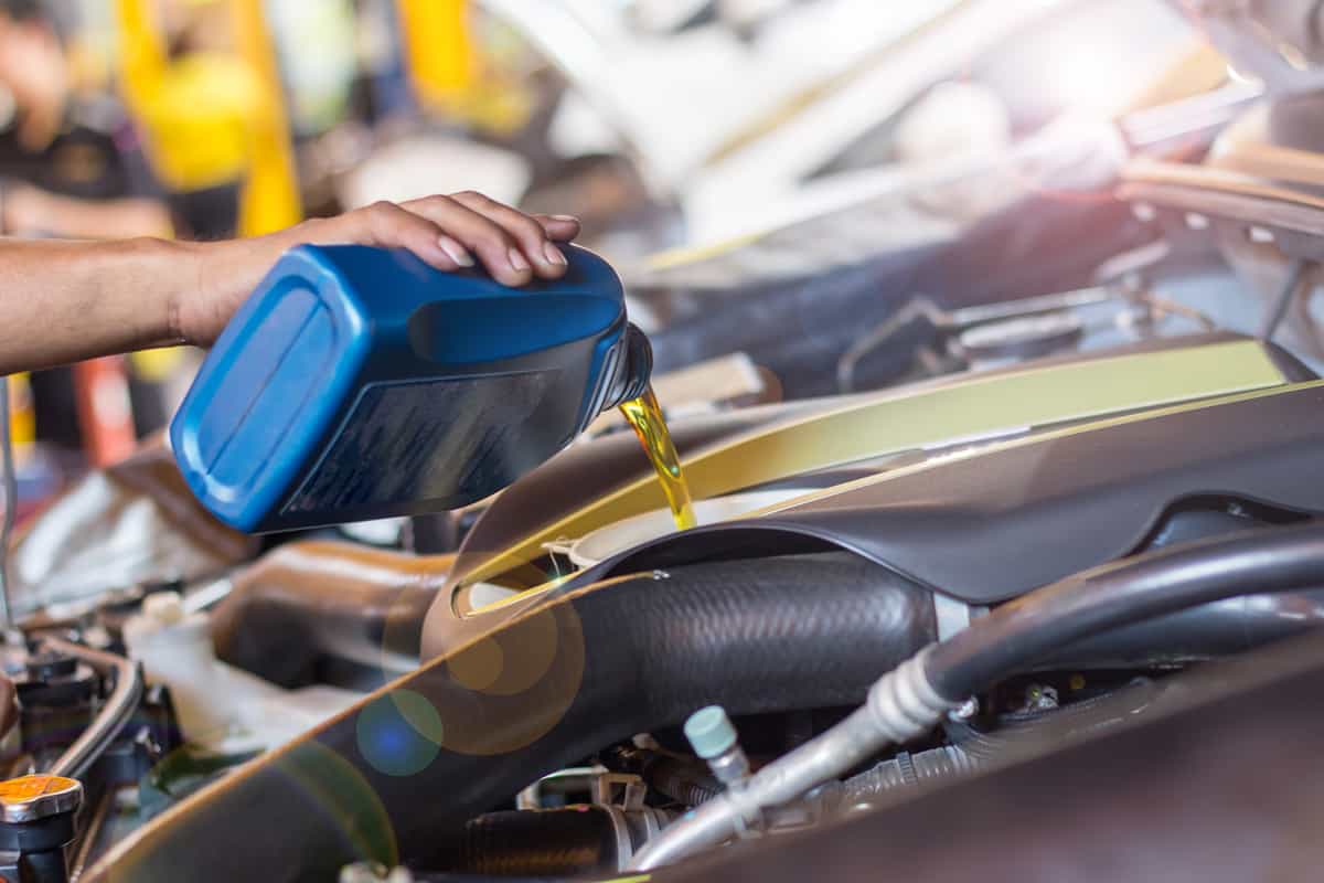 A mechanic pouring synthetic oil into an old engine, Is Synthetic Oil Bad For Old Engines?