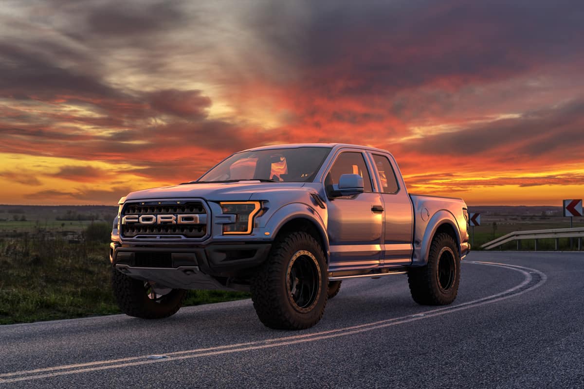 A single cab Ford F-150 Raptor moving down the road at sunset, Why Does My Truck Burn Oil? [And what to do about it]
