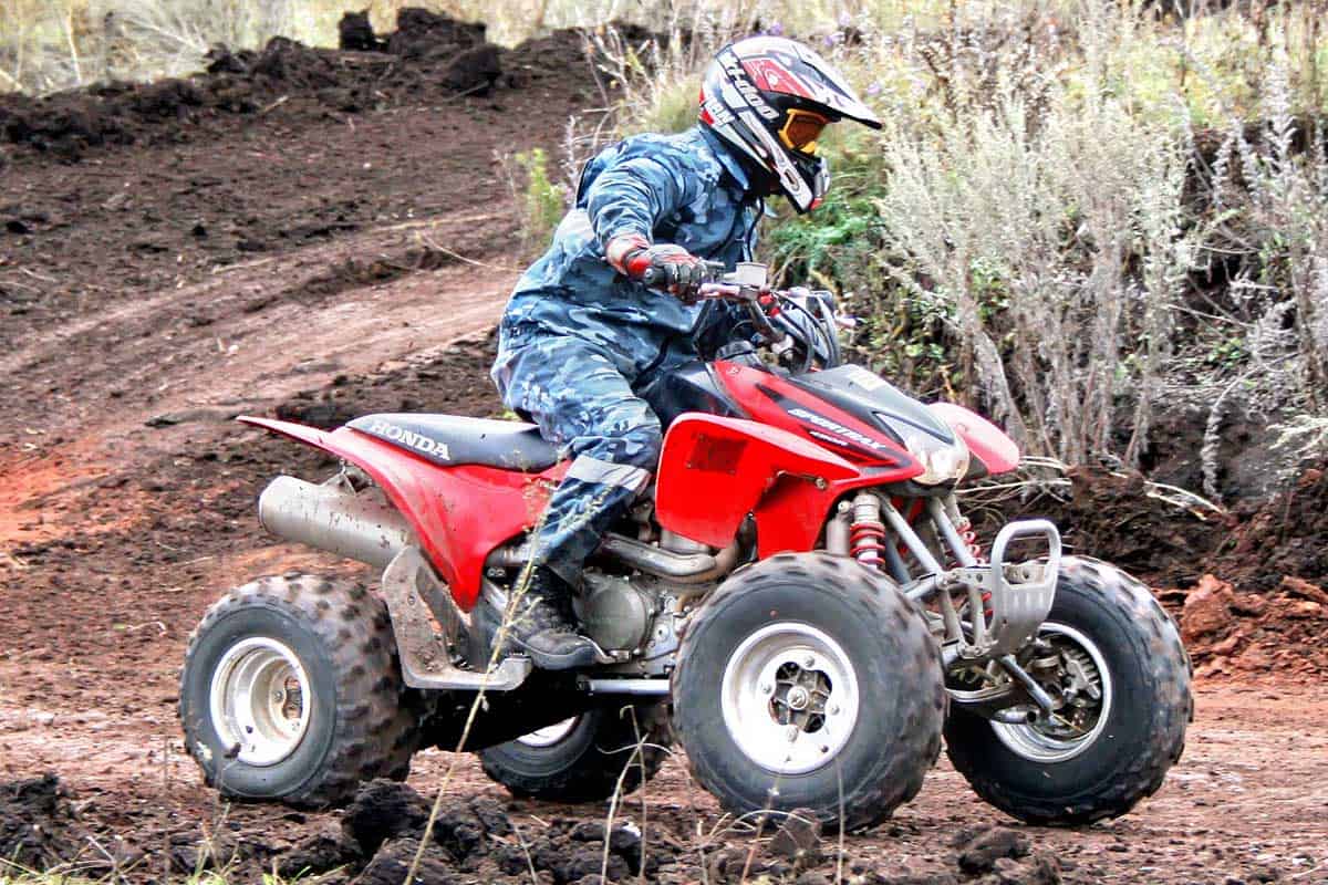 ATV rider in action racing with quad bike on a muddy road, Does the Honda 90 ATV Have Reverse?