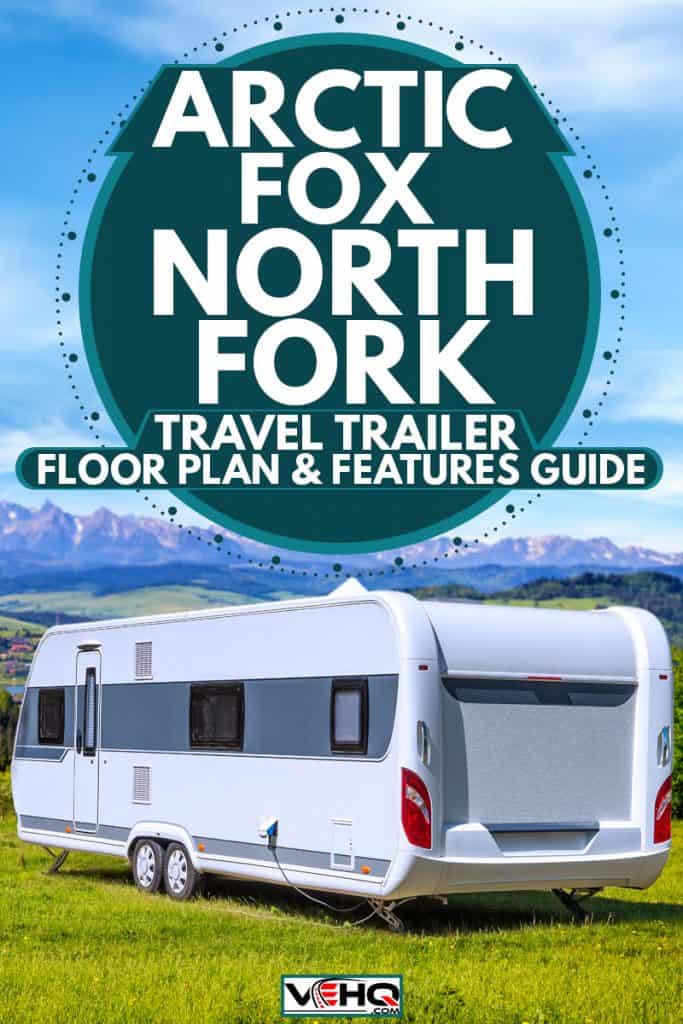 An Artic Fox RV parked on a hill with a panoramic view of a town surrounded by mountain ranges and blue skies, Arctic Fox North Fork Travel Trailer Floor Plans & Features Guide