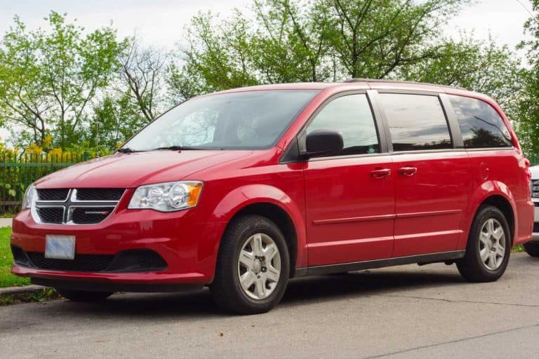 Red colored Dodge Grand Caravan minivan parked on the street, Here's What The Dodge Grand Caravan Interior Is Like