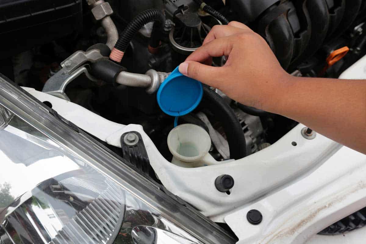 Woman's hands open lid for check water in reservoir for cleaning windscreen of her car, Can You Use Water As Washer Fluid?