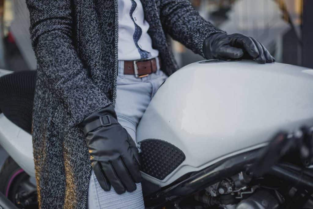 Young attractive man with sunglasses, gloves and coat sitting on customized naked motorcycle, How Do You Keep Your Hands Warm On A Motorcycle?