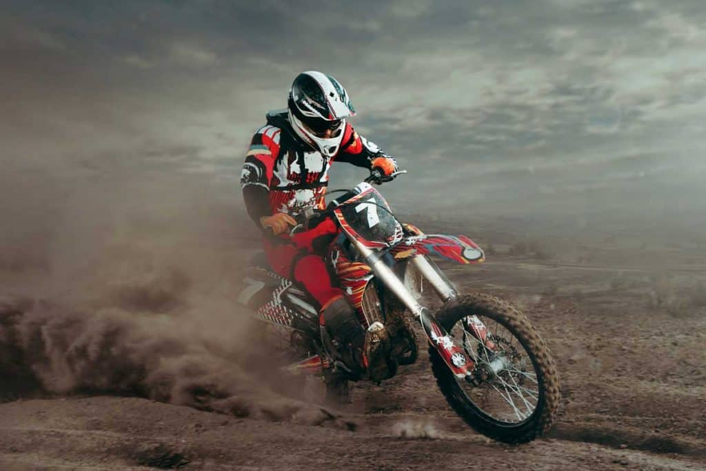motorcross rider wearing motorcycle suits on dirt, What Are Motorcycle Racing Suits Made Of?