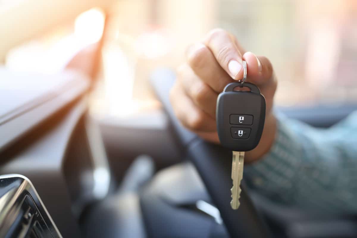 A man holding the car key of his convertible car, Can A Car Key Get Worn Out? (And What To Do About It)
