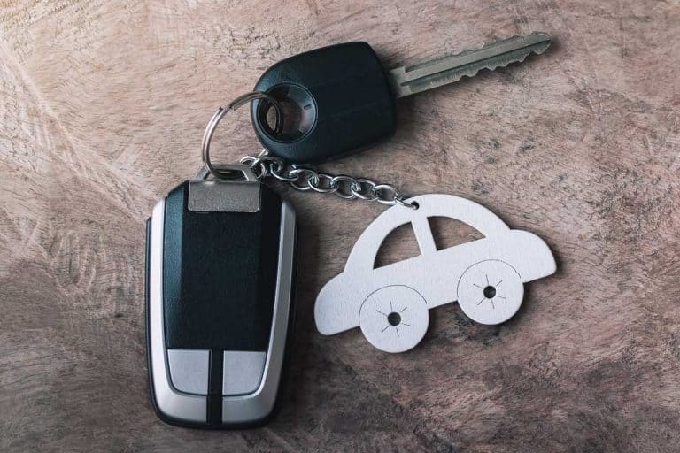 Car key and remote with car keychain on an old wooden table, Where Should You Leave Your Car Keys At Night?