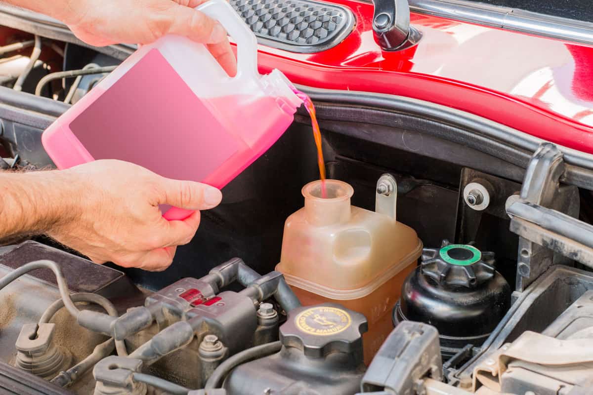 A man pouring coolant on the engine
