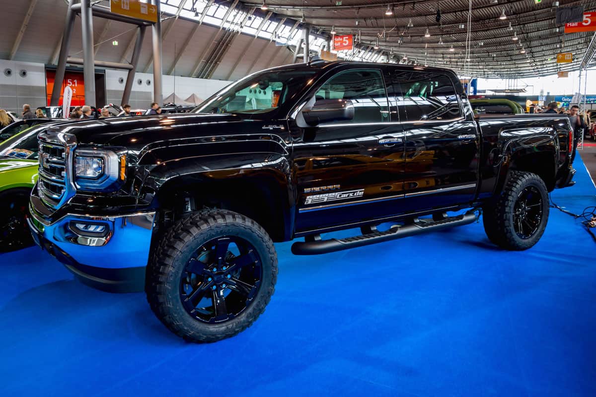 GMC truck with huge 22 inch tires and a modified lifted chassis displayed at a car show, Can A GMC Canyon Be Flat Towed?