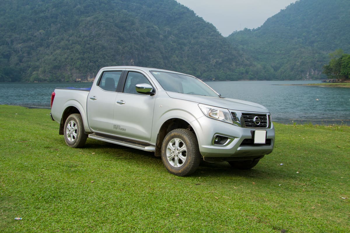 A gray Nissan Frontier parked near the side of a lake