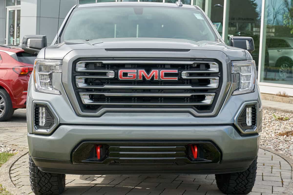 GMC Canyon truck parked outside a car dealership, Can A GMC Canyon Pull A Travel Trailer? [Towing Capacity Numbers]
