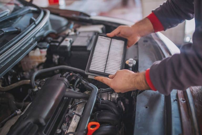 Mechanic holding and removing a car air filter, How Much Does It Cost To Replace Engine Air Filter?