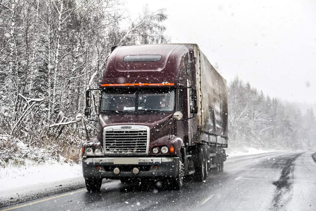 Semi-trailer truck Freightliner Century Class drives at the interurban freeway during a heavy snowfall, How Many Miles Does A Semi Truck Last?
