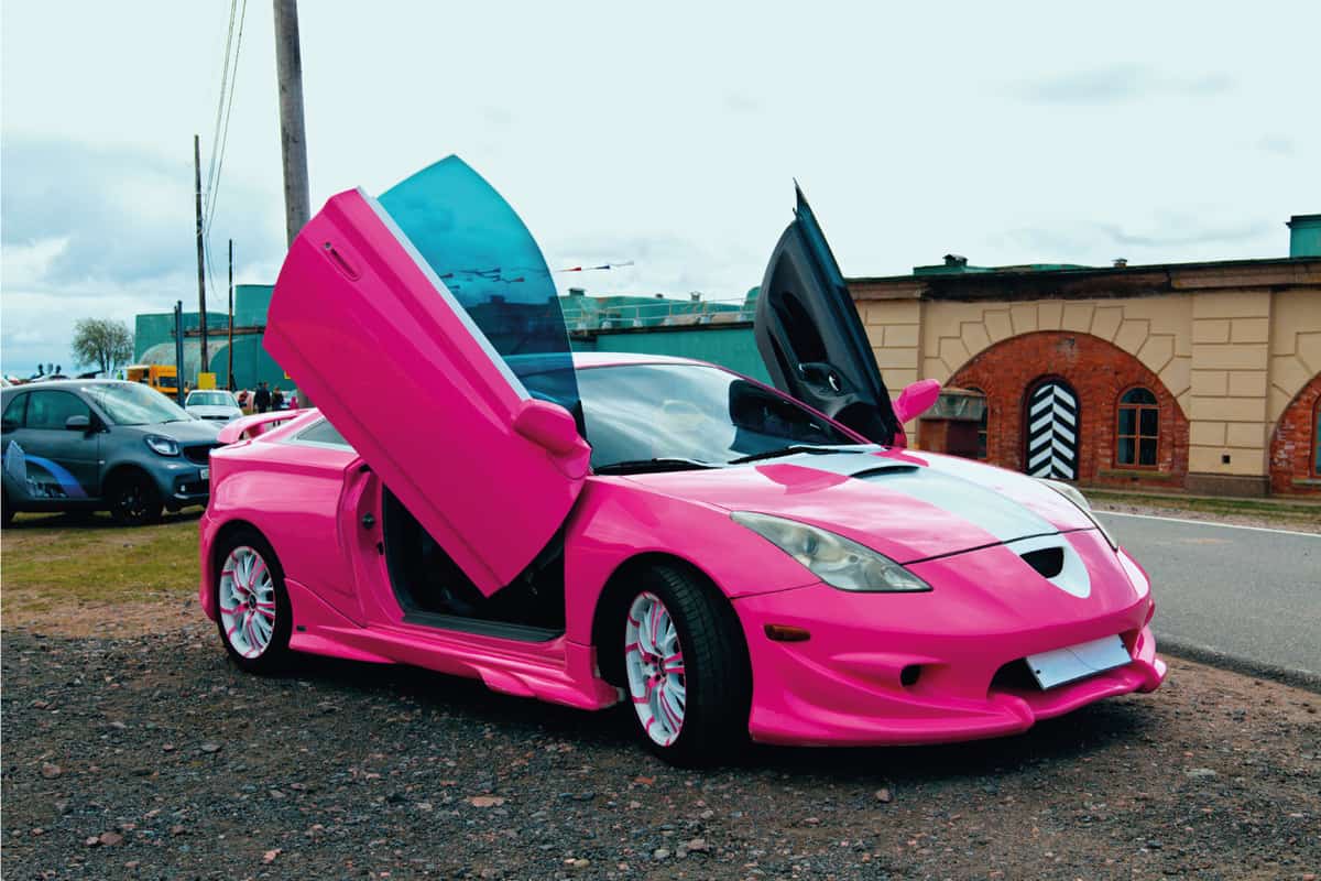 Pink Japanese tuner car with scissor type doors in a motor show