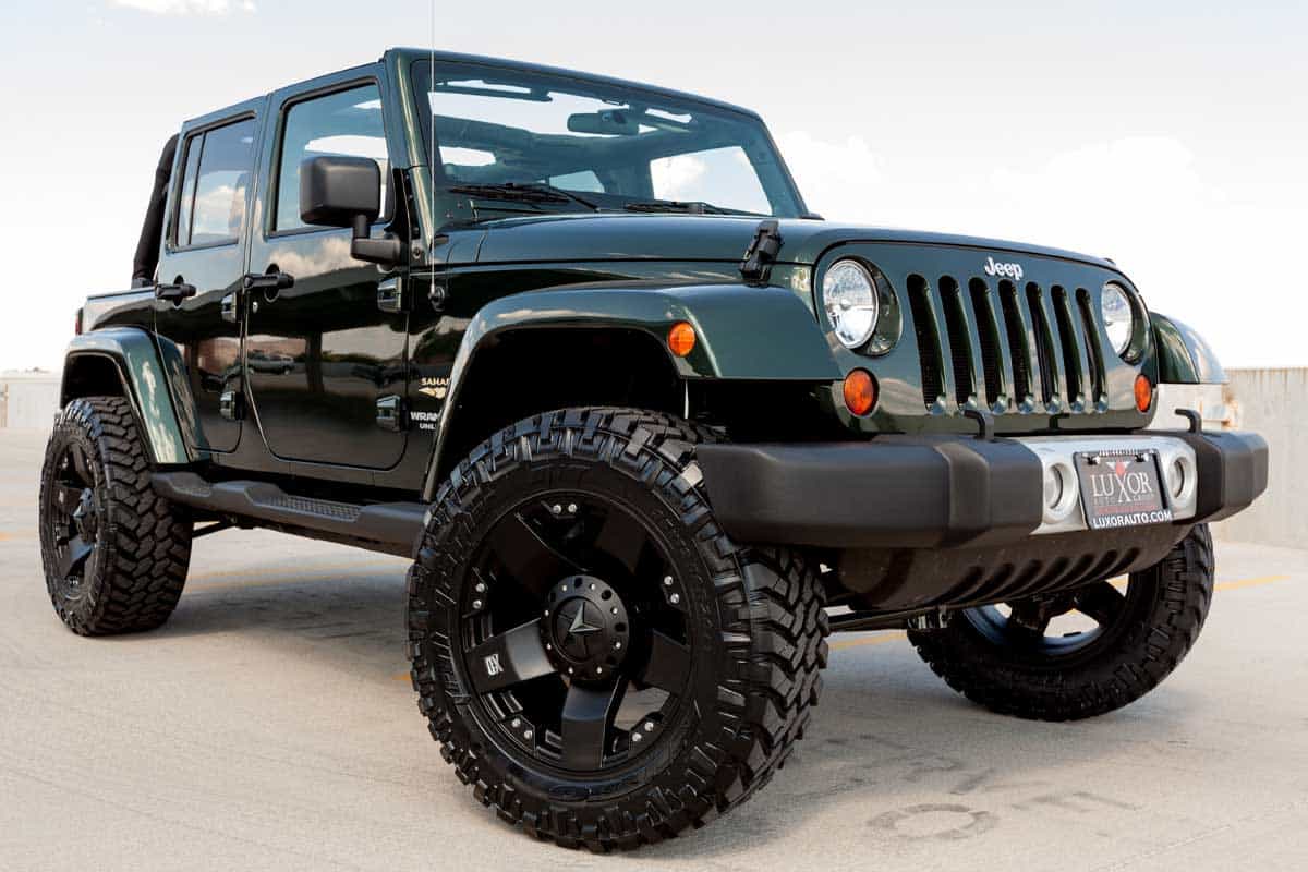 A parked green Jeep Wrangler with custom lift kit and wheels, How Much Does It Cost To Re-gear A Jeep?