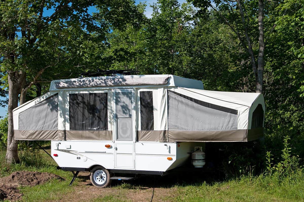 A single pop-up tent trailer in a campground